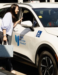 women speaking beside an On-Request vehicle speaking to the driver